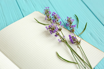 Lavender with notebook on wooden background