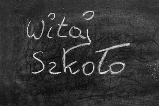 Tablica szkolna. Napis kredą na tablicy: Witaj Szkoło.