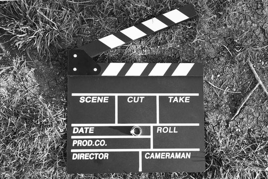 clapper board with an engagement ring, black and white photo