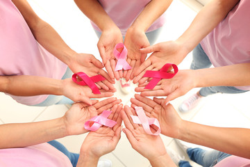 Female hands holding pink ribbons. Breast cancer concept