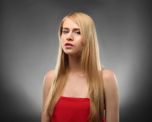 Naklejka premium Young blonde woman with long hair on color background