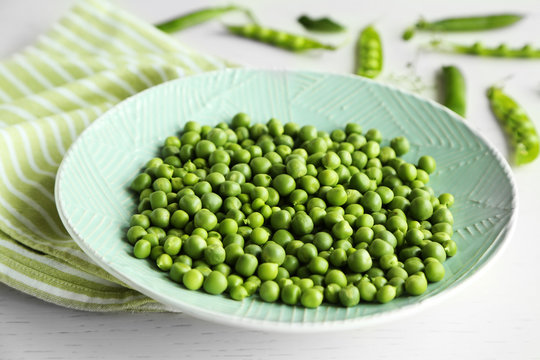 Fresh green peas in plate on napkin