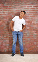 Obraz na płótnie Canvas African American boy on brick wall background