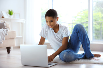 African American boy with laptop at home