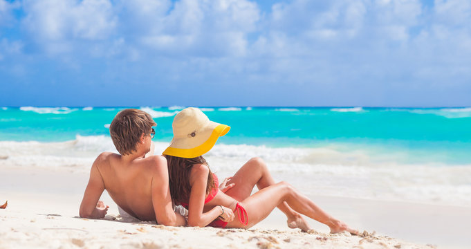 back view of couple sitting on a tropical beach in Barbados