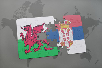puzzle with the national flag of wales and serbia on a world map background.