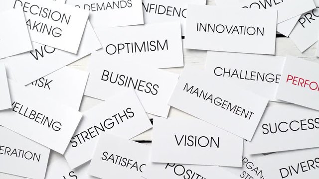 Business related concepts in a tag cloud on cards with one text in red: performance. Success plan for a company. Dolly shot.