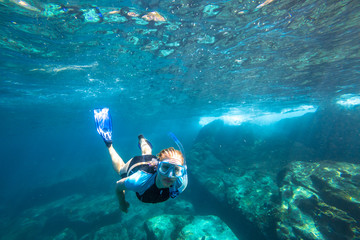Female apnea swims in deep waters of the popular Similan Islands in Thailand, Andaman Sea.