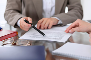 Group of business people and lawyers discussing contract papers sitting at the table, close up