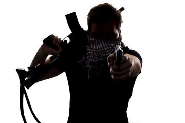 Ambiguous silhouette of a terrorist or a soldier with a rifle and a handgun