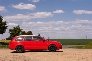 Fototapeta na wymiar Rotes Auto vor Landschaft