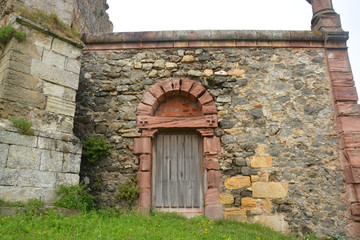 Fototapeta na wymiar puerta antigua en una muralla de piedra