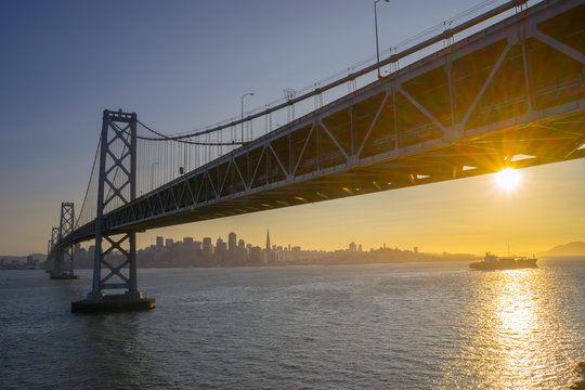 Container ship sails along San Francisco Bay at sunset