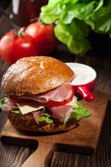Delicious sandwich with prosciutto ham, cheese and vegetables