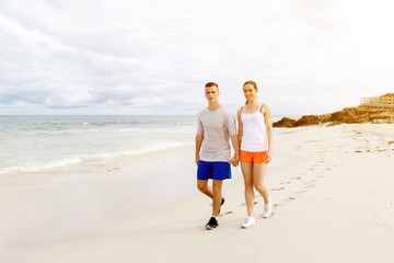 Runners. Young couple running on beach