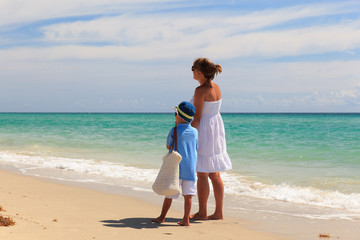 mother with little son walking on the beach