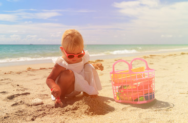 little girl play with sand on beach