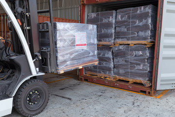 Forklift driver stacking of rubber briquette packs in to contain box