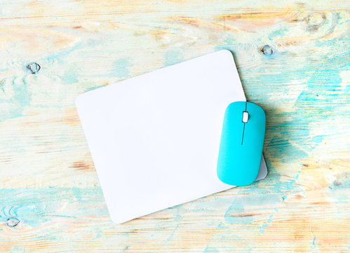 white pad with blue mouse on colorful wooden background
