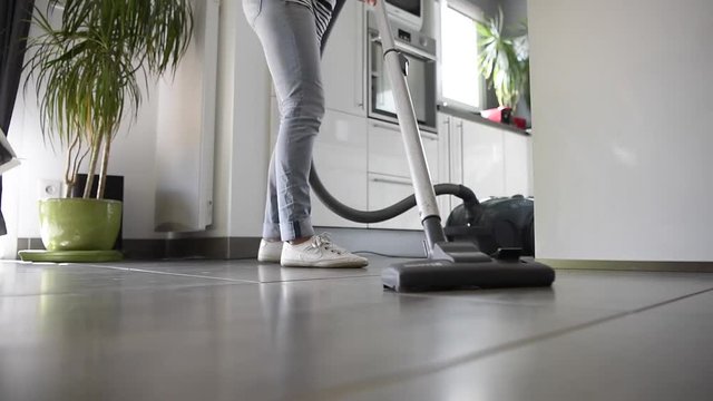 Homehelp vacuuming kitchen floor