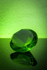 Bright green emerald on a shiny table