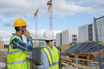 engineers using mobile phone at construction site