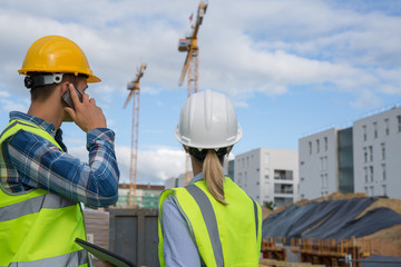 engineers using mobile phone at construction site