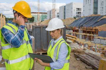 engineers using mobile phone at construction site