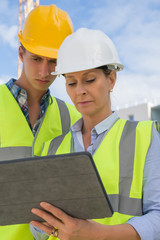 Two construction site workers in hard hats