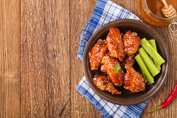 Baked chicken wings in honey sauce sprinkled with sesame seeds.