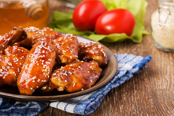 Baked chicken wings in honey sauce sprinkled with sesame seeds.