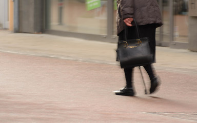 Alte Frau mit Tasche und Stock alleine unterwegs, Symbolbild