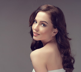 Naklejka premium Beautiful girl with long wavy hair . Brunette with curly hairstyle