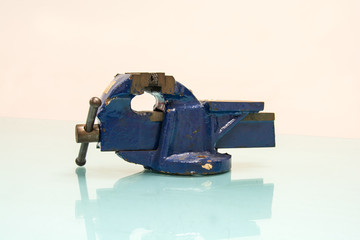 Blue steel vise on table background