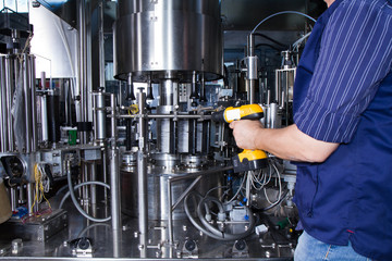 skilled worker while fixing a bottling plant during maintenance work