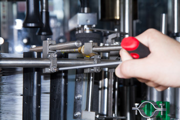 skilled worker while fixing a bottling plant during maintenance work