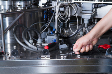 skilled worker while fixing a bottling plant during maintenance work