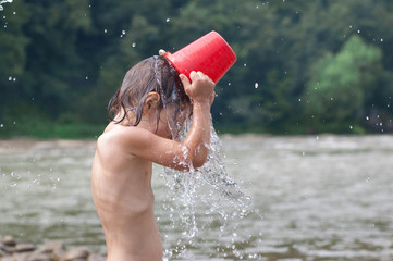 I am hot. Child pours over itself water.