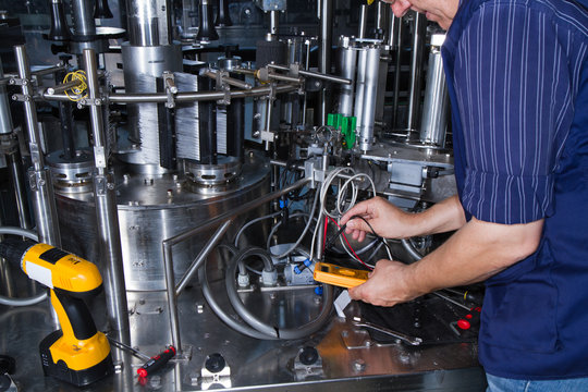 Skilled Worker While Fixing A Bottling Plant During Maintenance Work