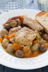 rabbit stew with mushrooms and carrot on white dish on blue background