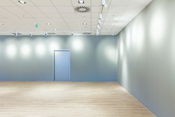 Spotlight reflection on the wall with air duct on ceiling, close