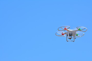 Flying quadcopter in clear blue sky