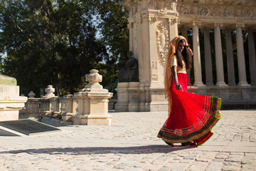 Young beautiful traditional indian woman dancing outdoors