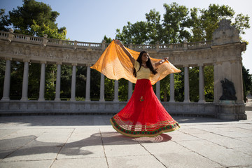 Young beautiful traditional indian woman dancing outdoors