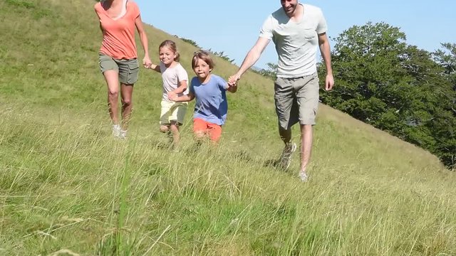 Family on vacation running down the hill