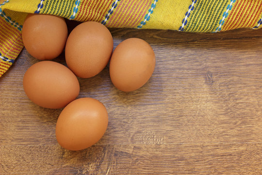 Raw eggs on a wooden background top view.