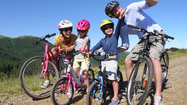Family on a biking day, parents pointing at scenery