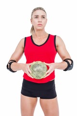 Female athlete with elbow pad holding handball