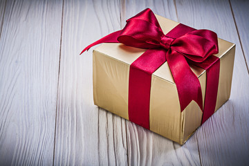 Present box with red tape on wooden board holidays concept