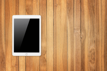 Digital tablet on wooden background.